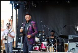 A close up shot of an older gentleman singing.