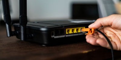 maxxsouth blog, office router reboot, man plugging cord into router