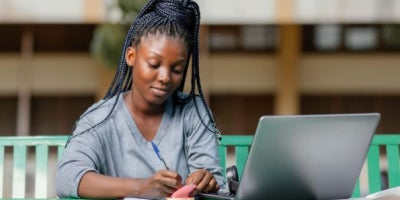 best laptops for college, laptops for school, student with braids on a laptop