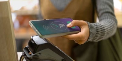 maxxcommunity blog, retail technology, retail customer experience, woman using phone to pay