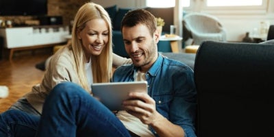 maxxcommunity blog, fiber internet vs traditional cable internet, happy couple on tablet