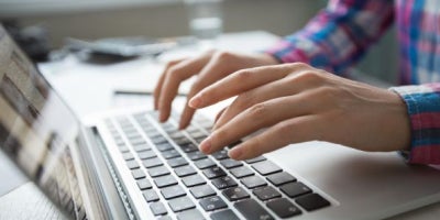 laptop vs chromebook differences, woman typing on computer