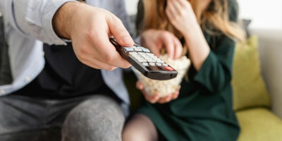 Couple sitting on the couch at home watching TV.