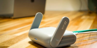 Close-up of a WiFi 6 router on top of a wooden surface.