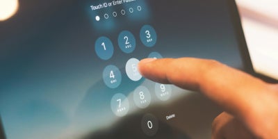 Person clicking number 5 to enter passcode on a touch screen device