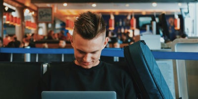 Young man using a public WiFi network on his laptop.