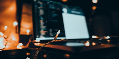 Laptop on a desk beside string lights, a common source of WiFi interference at home