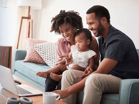Family on couch looking at laptop