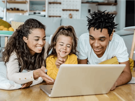 Family laying on floor watching laptop