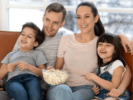 Family sitting on couch with popcorn