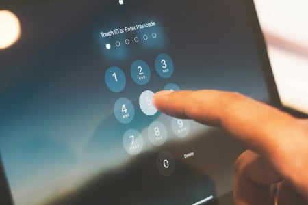 Person clicking number 5 to enter passcode on a touch screen device