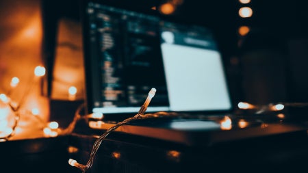 Laptop on a desk beside string lights, a common source of WiFi interference at home