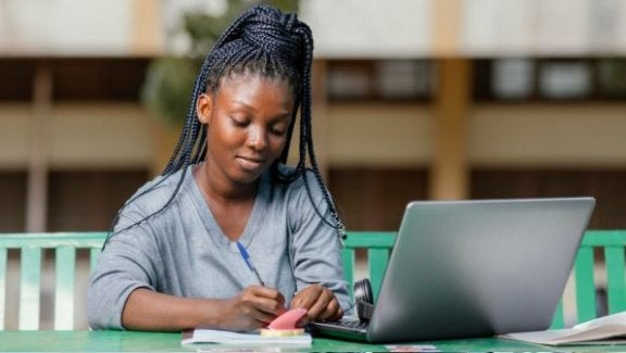 best laptops for college, laptops for school, student with braids on a laptop
