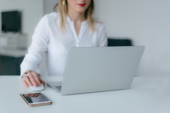 Woman using a mobile hotspot to get internet on her laptop