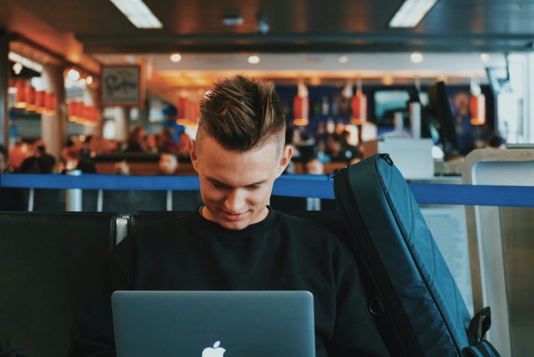 Young man using a public WiFi network on his laptop.