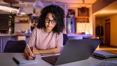 Woman working on laptop computer in dorm room utilizing MaxxSouth student internet in Oxford, Mississippi
