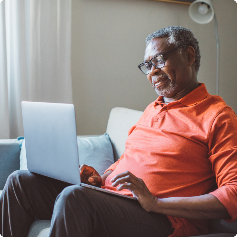senior on couch using laptop