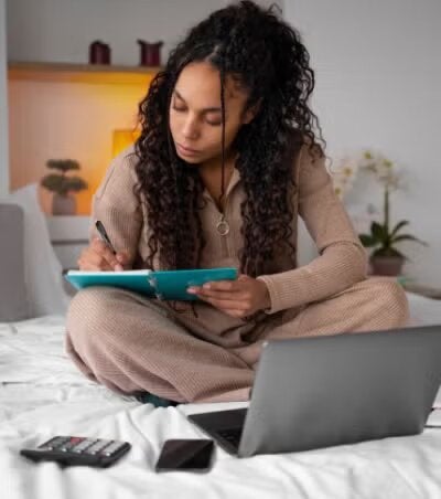 Student sitting on bed doing homework